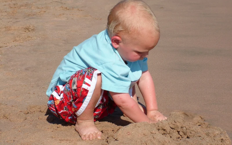 Candid outdoor portrait of a young child playing naturally in the beach sand